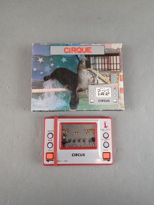 a small electronic game that is sitting next to a box