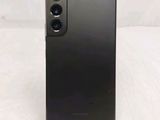 a close up of the back of a black phone on a white surface