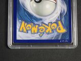 a pokemon card in a plastic container on a table