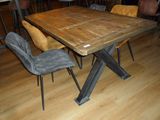 a wooden table with chairs around it in a room