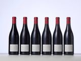 six bottles of wine lined up in a row on a table