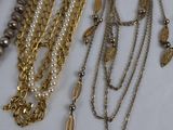a lot of necklaces that are laying on a table