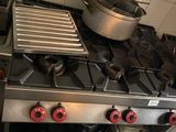 une cuisinière sur laquelle est posée une marmite dans une cuisine