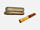 une cigarette et un étui à cigarettes sur fond blanc