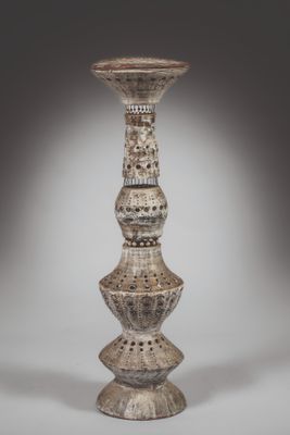 a tall vase that is made of wood and has a design on it