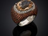 a close up of a ring with a large stone surrounded by diamonds