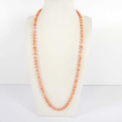 an orange beaded necklace on a mannequin neck
