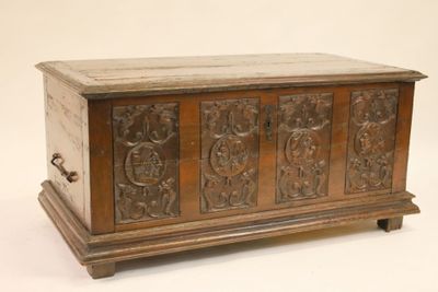 un vieux coffre en bois posé sur une surface blanche