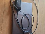 a laptop and headphones on the floor next to a charger