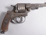 un vieux pistolet avec une poignée en bois sur une surface blanche