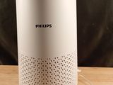 une enceinte blanche posée sur une table en bois