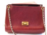a red purse with a gold chain hanging from it