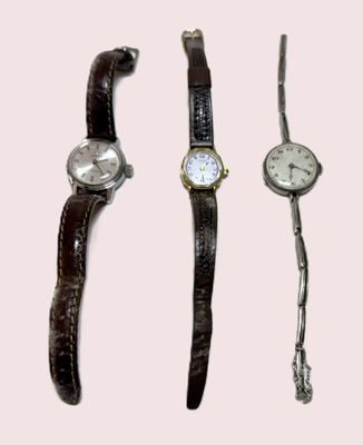 trois modèles de montres différents sur fond rose