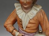 a figurine of a woman holding a birdcage