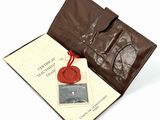 un portefeuille en cuir marron orné d'un cachet en cire rouge et d'un porte-cartes