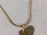 a gold necklace with two hearts hanging from it