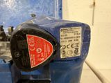 a close up of a blue machine with a red label on it