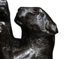 a black statue of a dog with its paw up