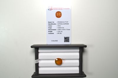 an orange ball sitting on top of a shelf next to a business card