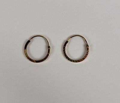 une paire de boucles d'oreilles en or sur fond blanc