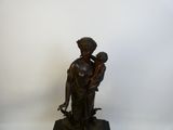 statue en bronze d'une femme tenant un enfant sur un socle en marbre