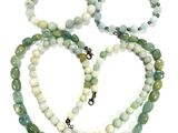 three bracelets with green and white beads on a white surface