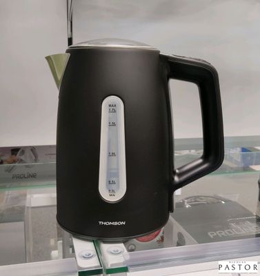 une bouilloire noire et blanche posée sur une étagère en verre
