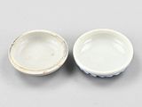 two small white bowls sitting next to each other on top of a table