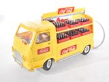 yellow toy truck with coca cola bottles on top of it on a white surface