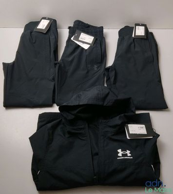 quatre paires de pantalons noirs pour homme posées sur une table