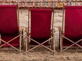 four red chairs sitting in a row on the beach