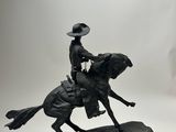 statue of a man riding a horse with a hat on top of it