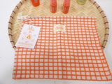 an orange and white checkered towel on a tray