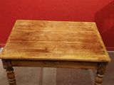a small wooden table with a red wall in the background