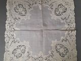 un morceau de dentelle blanche posé sur une nappe