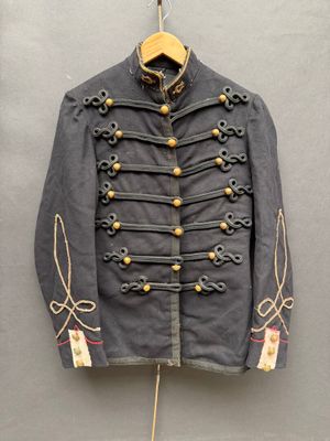 une vieille veste militaire accrochée au mur à côté d'un cintre en bois