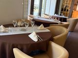 a dining room with tables and chairs and a table with a white table cloth