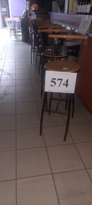 des tables et des chaises dans un restaurant, avec une affiche indiquant les prix devant elles