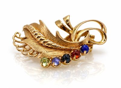 une image représentant une broche dorée ornée de pierres multicolores