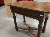 a wooden table with a drawer on it in the middle of a room