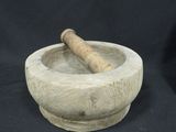 a stone mortar and a wooden stick in it