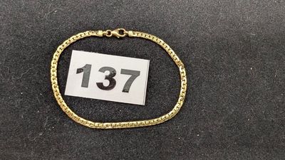 un gros plan d'un bracelet en or sur lequel figure un numéro