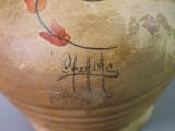a brown vase with a painting on it that says happy