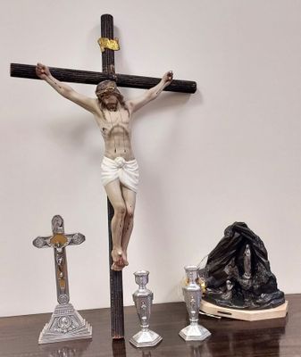 une statue de Jésus sur la croix, à côté de bougies