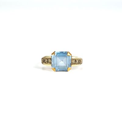 Gros plan sur une bague ornée d'une topaze bleue et de diamants
