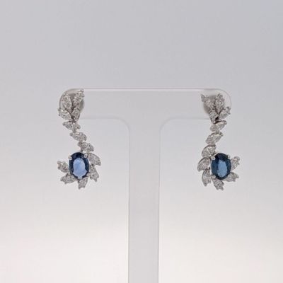 une photo d'une paire de boucles d'oreilles en diamant bleues et blanches