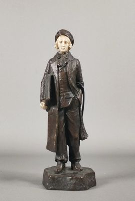 figurine représentant un homme en manteau et chapeau, debout sur un rocher