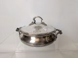 a silver plate with a lid on a glass shelf