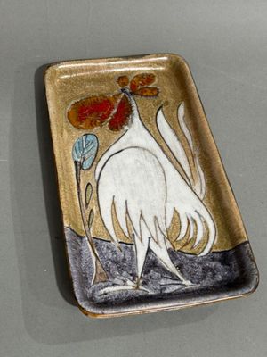 a plate with a rooster on it on a table