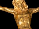 a gold statue of a man on a cross with his arms outstretched